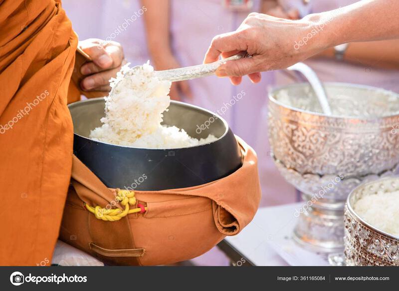 A layperson offering rice to a Buddhist monk