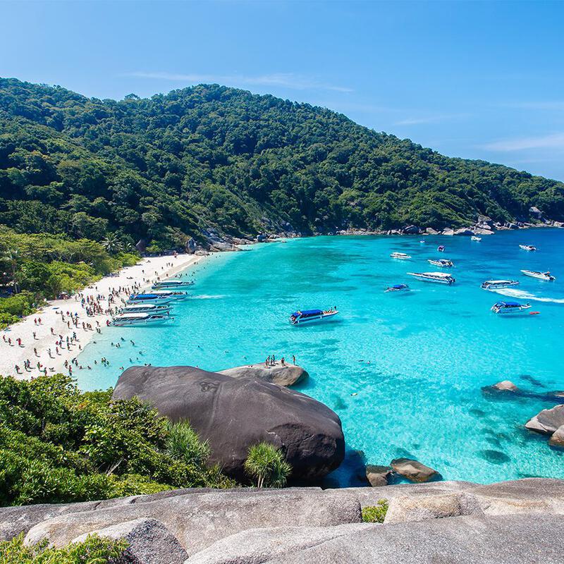 泰国斯米兰群岛海滩附近清澈的蓝色海水中有许多船只