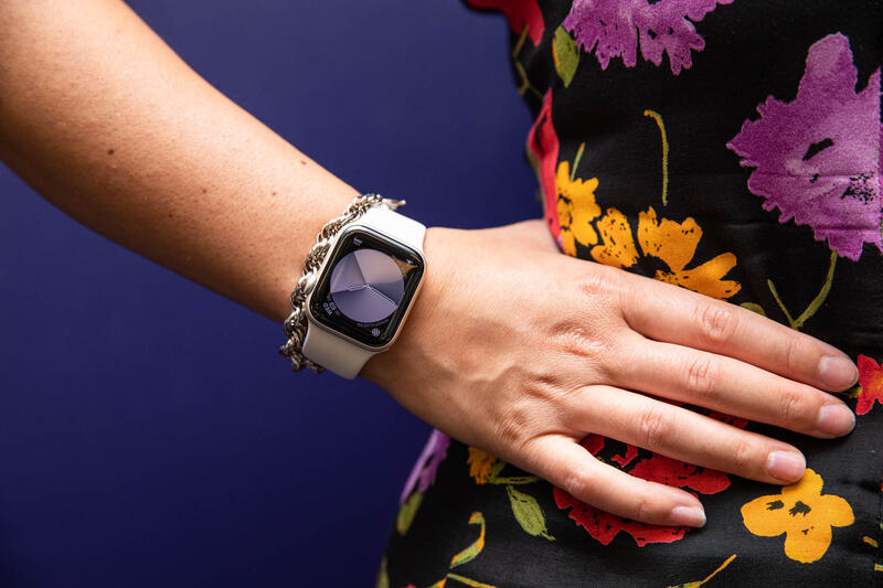 身穿花裙、手叉腰展示 Apple Watch SE(2022 款)的女士